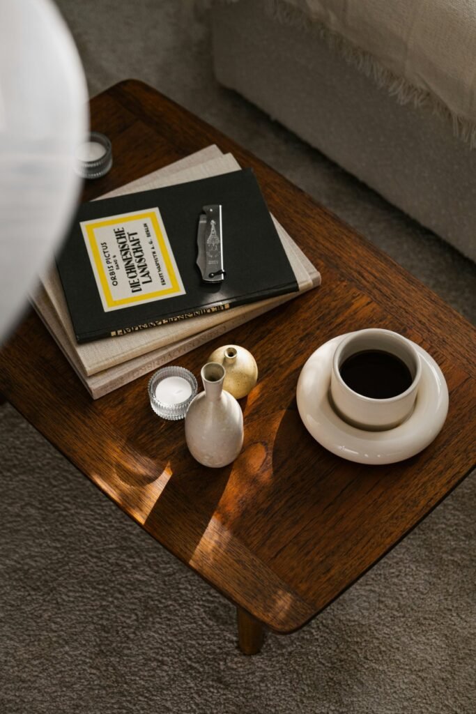 Libros y una taza de café sobre una mesita de madera