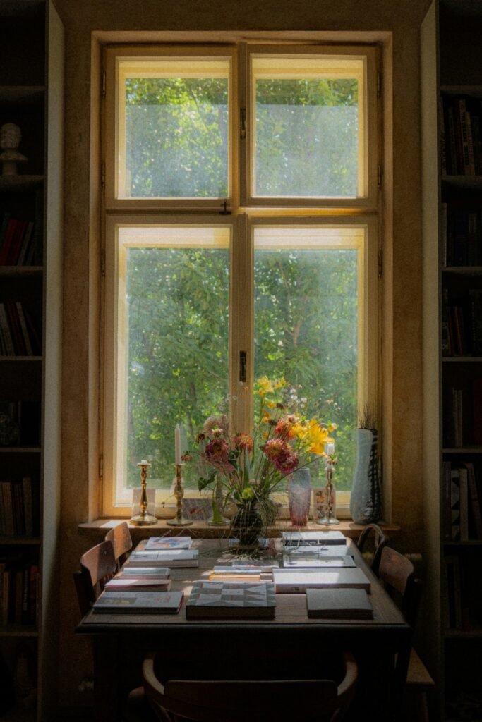 Ventana con vistas al jardín y una mesa con flores
